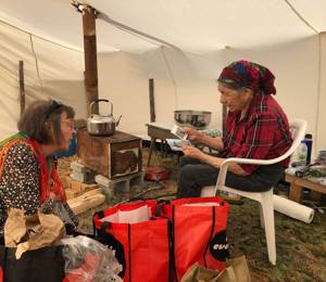 Elisabeth Utsi Gaup from Sami Allaskuvla visiting Elder Elisabeth Penasue at her tent.